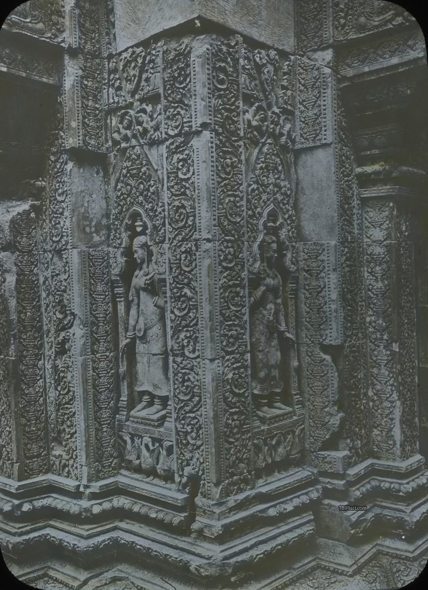 Hand-colored stone pillar with carved reliefs among weathered ruins