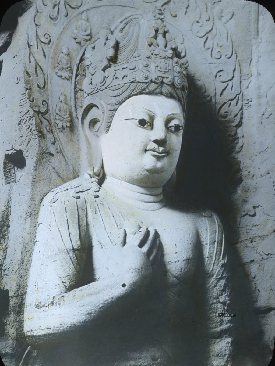 Handcolored stone Buddha relief with ornate headdress and raised hand