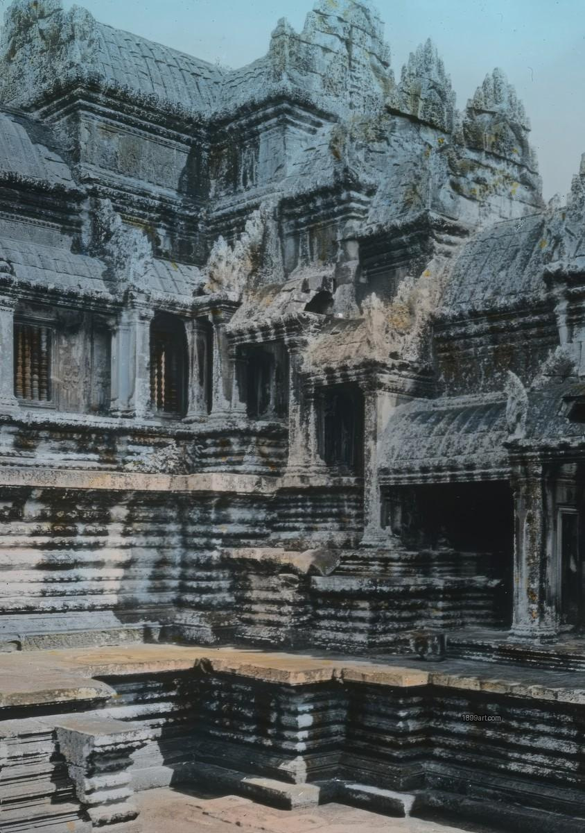 Hand-colored close view of weathered carved stone ruins at Angkor Wat
