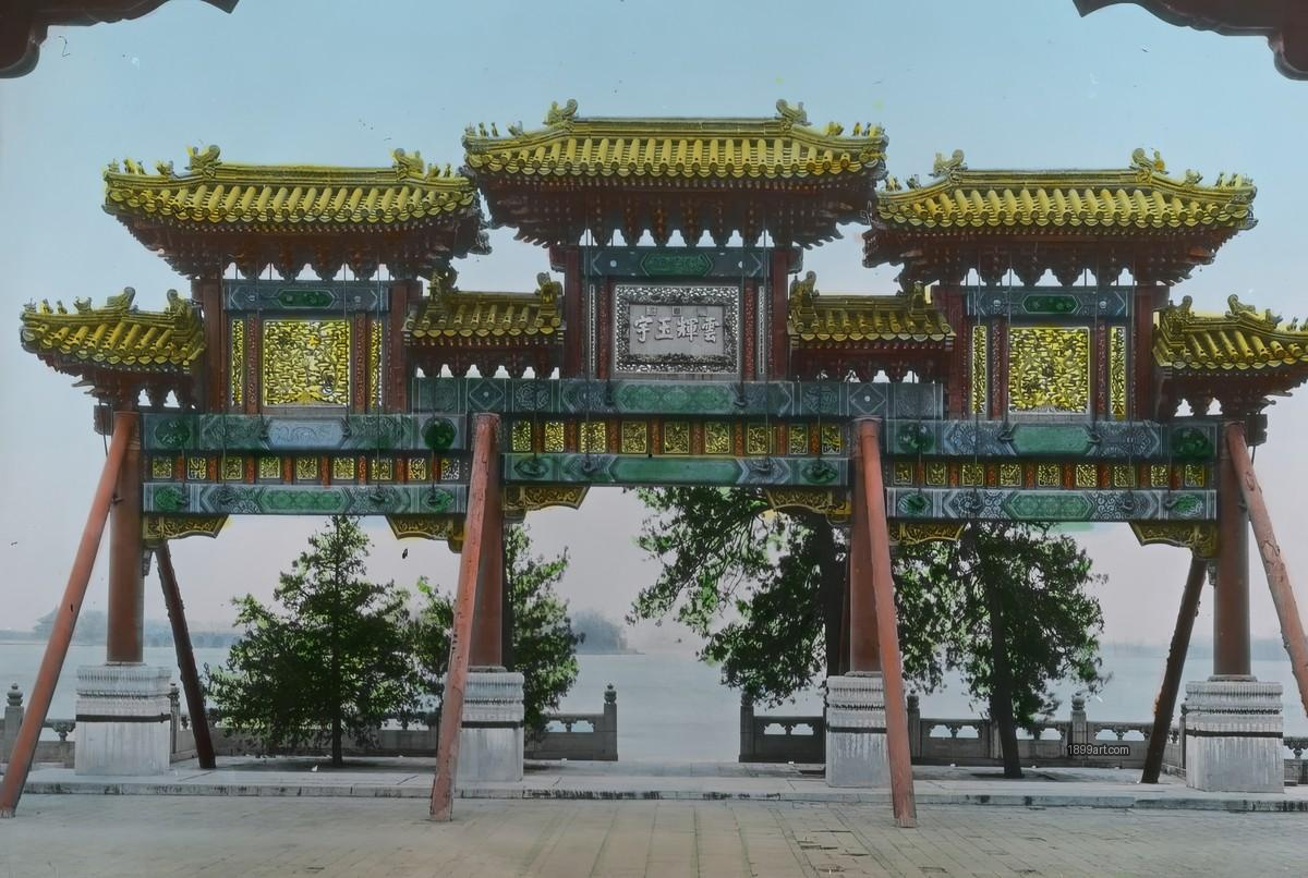 Handcolored Chinese temple gate with ornate roofs, trees, and water
