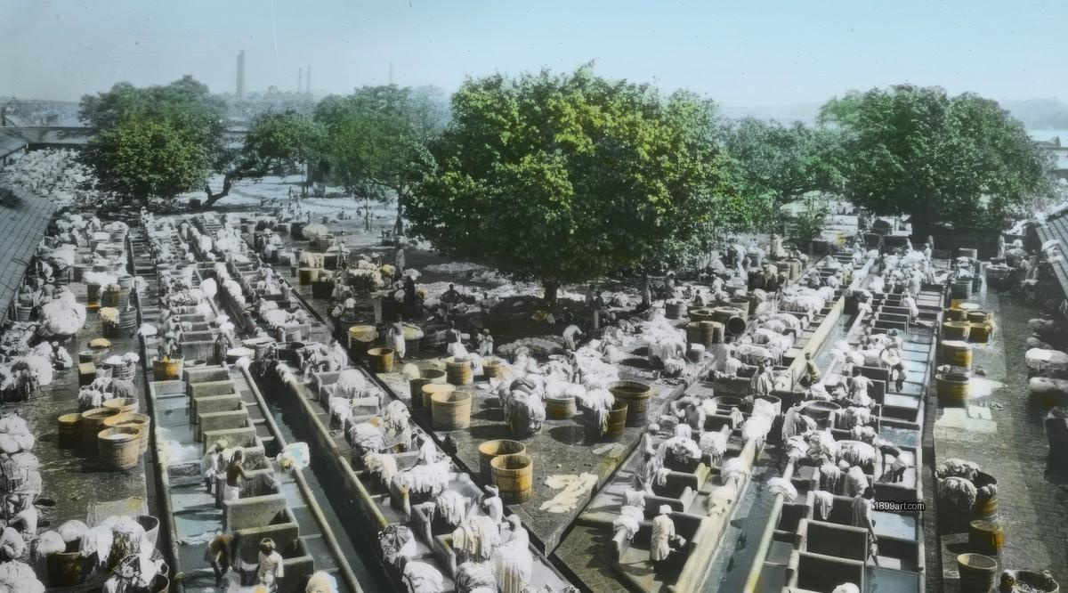 Handcolored view of many people washing at rows of outdoor stations