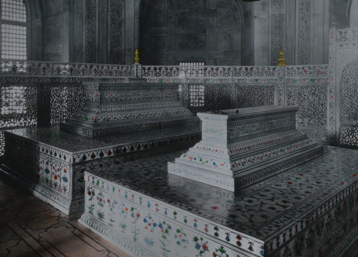 Two inlaid marble Mughal tombs enclosed by an ornate railing indoors