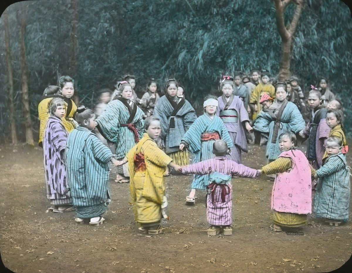 Children in kimonos hold hands in a circle around blindfolded child
