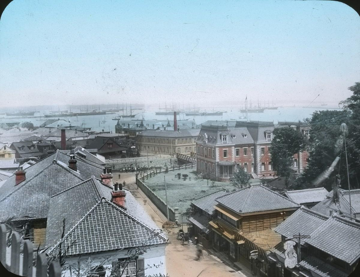 Handcolored waterfront scene with buildings, greenery, and anchored sailing ships