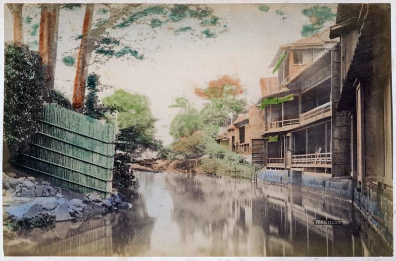 1899art Waterside houses and canal at Oji, Tokyo, Japan, with wooden fence along the left bank Handcolored 1900s 1899art. Historical photograph from the 1899art Archive.
