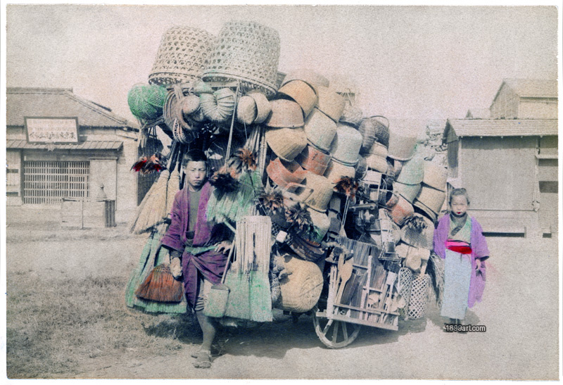 1899art Brother and Sister beside a Handcart Loaded with Baskets and Brooms, Japan, 1880 Handcolored 1900s 1899art. Historical photograph from the 1899art Archive.